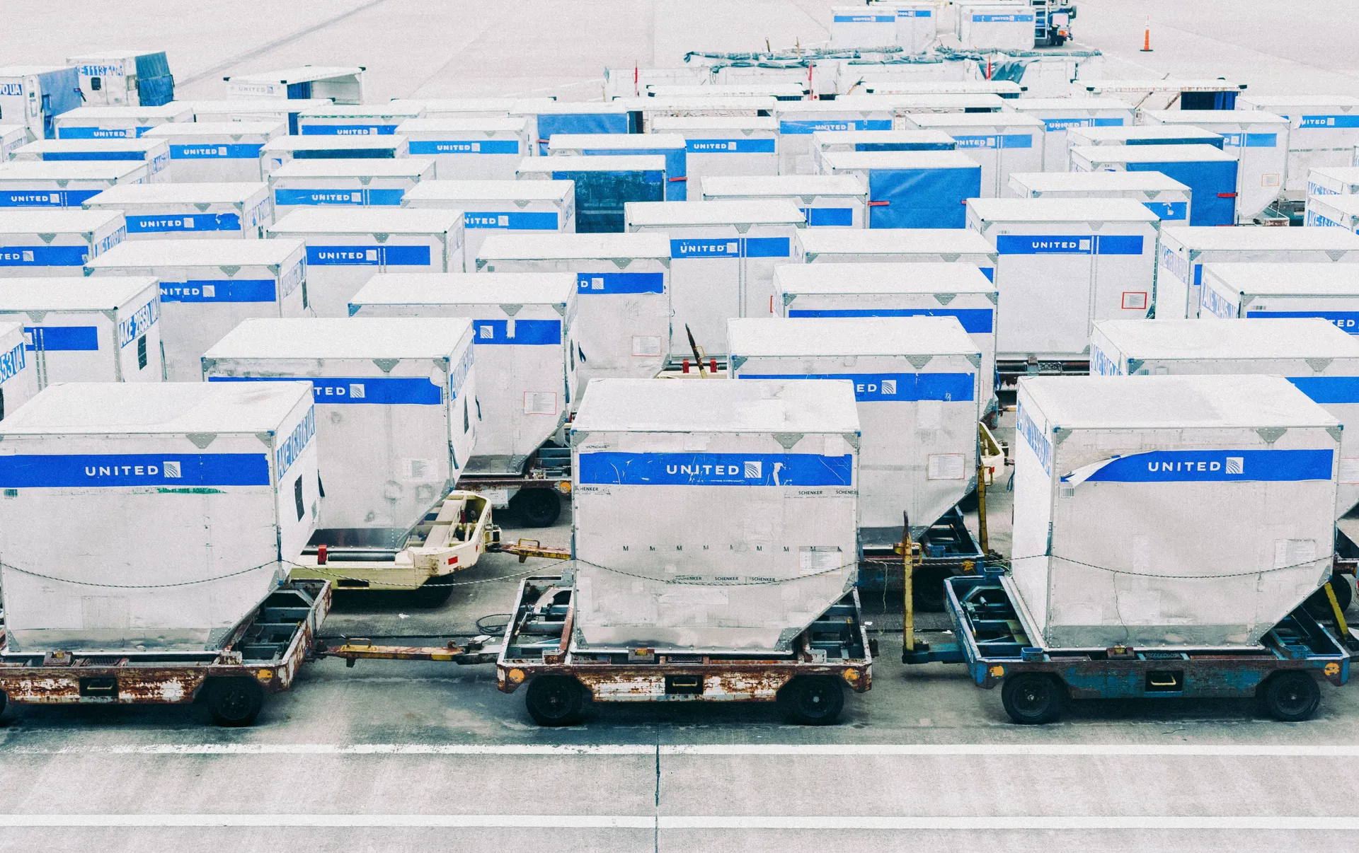 Filas de contenedores ULD de carga aérea preparados en plataforma
