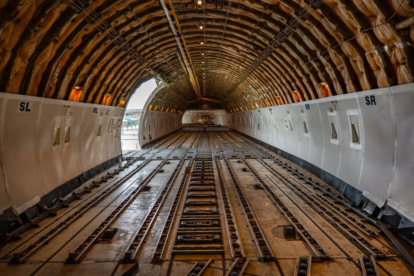 Bodega principal de un avión carguero vacía, con el sistema de rodillos y raíles para contenedores a la vista