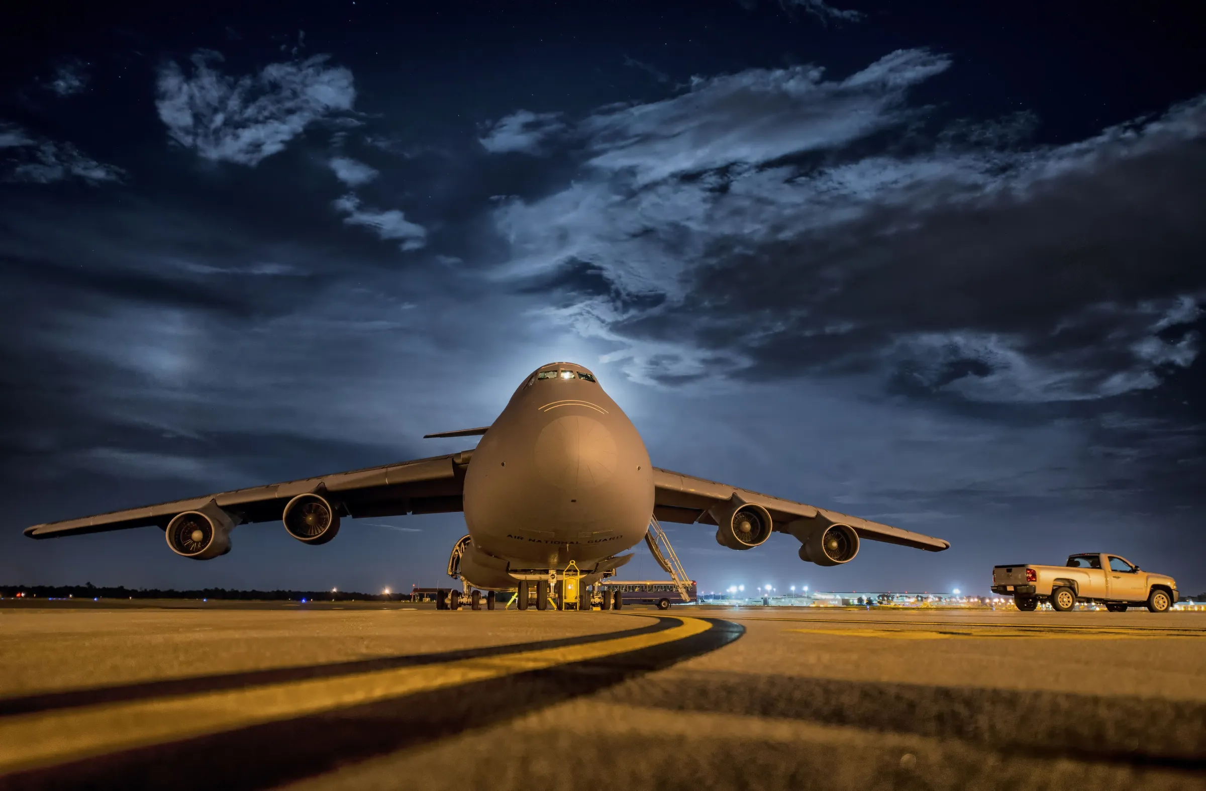 Avión de carga en pista de noche, con la iluminación ámbar del aeropuerto